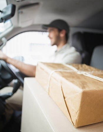 A courier loading parcels into a van